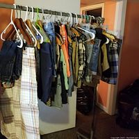 Wide view of assorted pants and shorts on hangers, multiple colors and patterns visible