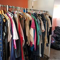 Wide view of assorted women's clothes hanging on racks, showing various colors and styles including jeans, tops, and outerwear.