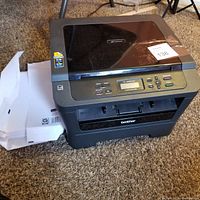 Full view of the Brother HL-2280DW laser printer and scanner showing control buttons, paper output tray, and top flatbed scanner lid closed.