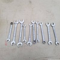 Set of 10 open end wrenches laid out on a flat surface showing sizes.