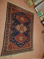 Full view of rug angled showing central design and fringes