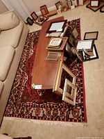 Rug laid under coffee table and sofa with picture frames around edges
