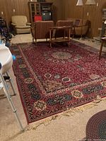 Overall view of full rug in basement setting with furniture