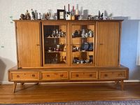 Front view of assembled two-piece china cabinet with items inside (contents not included)