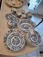 Wide view of plates, cups, saucer stacks and serving pieces on table