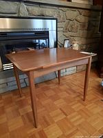 Front view of larger nesting table showing overall shape and leg style