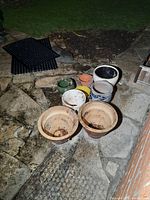 Photo showing various planters arranged on a stone patio, highlighting the variety in size, shape and color.