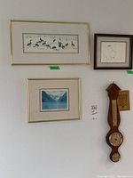Three framed bird prints and a wooden barometer mounted on a wall