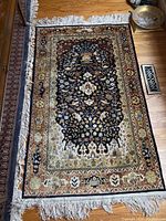 Full top view of rectangular rug showing entire floral design, borders and fringe