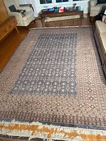 Overall view of rug laid on hardwood floor between sofas