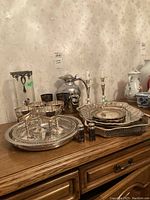 Overview on sideboard showing trays, goblets, candlesticks, shakers, coffee pot, ice bucket and vase