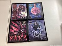 Four framed 8x10 WWF wrestling pictures laid out on a white surface featuring Mankind, Stone Cold Steve Austin, Kane, and The Undertaker.