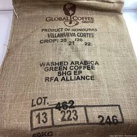 Front side of burlap coffee bean bag with Global Coffee Group logo, product origin Honduras, washed Arabica green coffee details.