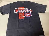 Front view of navy blue Montreal Canadiens t-shirt showing colorful single stitch graphic on chest area