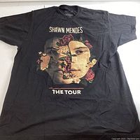 Front view of black Shawn Mendes concert t-shirt with split portrait and floral design