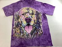 Front view of purple tie-dye t-shirt with large colorful Golden Retriever face graphic.
