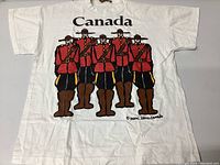 Front of white XL vintage T-shirt showing graphic of five Canadian Mounties in red and brown with 'Canada' text
