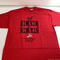 Front view of bright red T-shirt with black WWF Raw is War graphic and sponsor text beneath.