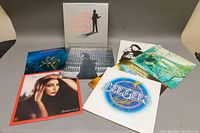 Full view of all 8 vinyl records' cover art arranged on surface, showing album titles and art for identification