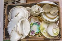 Top-down view of the assorted chinaware in a box including teapot, plates, cups, and serving pieces