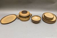 Full view of all pieces including casserole dish with lid, oval platter, stack of dinner plates, dessert plates, and cereal bowls