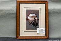 Framed carved stained glass wall art depicting a person in a canoe on a lake with a sunset, titled "Solitaire".