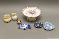 All seven assorted chinaware pieces including the Royal Crown Derby mints dish, Belleek creamer and sugar bowl, floral hand-painted serving plate, and four small decorative dishes.