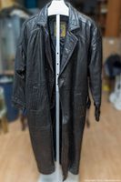 Full front view of vintage men's long black leather duster coat on mannequin, showing overall length and condition.