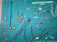 Wide view showing assortment of necklaces laid out, various styles and pendant designs visible.