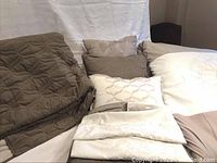 Set components arranged on a surface: comforter, pillow shams, throw pillows, and blanket visible