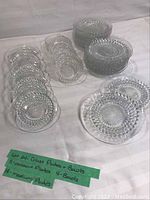All items displayed on a white cloth surface showing three groups: bowls stacked, two stacks of plates, and 5 dessert plates set on a separate plate.