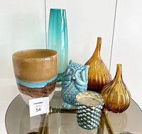 Full lot overview showing all six items on glass table including vases, owl figurine, and candle holder