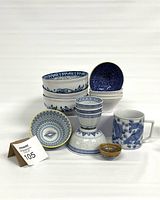 Full lot of mix match blue and white ceramics including bowls, mugs, plates and a candlestick holder