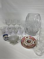 Wide shot of entire lot showing crystal vase, multiple glasses, porcelain cups and small plates.