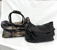 Side-by-side view of the black leather Kate Spade bag and floral tapestry carpetbag in good condition