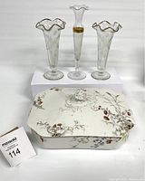 Full shot showing Limoges covered dish with woodland scene in front and three Bohemian glass bud vases with etched patterns and gold accent behind on white background.