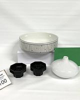 Photo showing the white Ikea vintage glass vase, set of two black Acropal candle holders, and large Mikasa serving bowl all displayed on white stands.