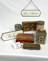 Photo showing the full lot with mixed tins and hanging signs against a white background