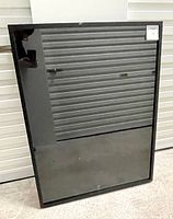 Front view of one large wall shadow box with clear glass front and black frame showing reflections and some scuffs.