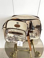 Both vintage tapestry travel bags with Japanese garden scenes visible on front panels, placed on glass table