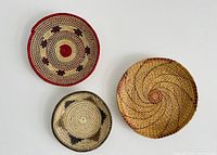 Top-down view of the three woven baskets arranged on a white background showing patterns and sizes.