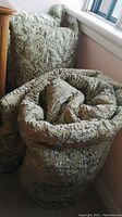 Rolled patterned velveteen bedspread showing textured floral design and thickness