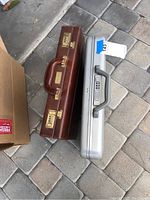 Two briefcases placed on a paved surface, showing side-by-side top view with combination locks and handles.
