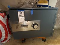 Front view of the Meilink floor safe showing the combination dial, key lock with key, handle, and Meilink branding.