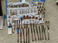 Overhead view of entire flatware laid out, showing all forks, spoons, spreaders and server.