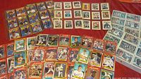 Various baseball trading cards arranged, showing multiple players, teams, and card styles with colorful borders.