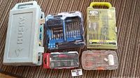 Photo of the entire lot including Husky case, Kobalt drill bit set, Ryobi drill bit set, Task Force screwdriver set, and small bit case