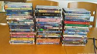 Three stacks of children's DVD movies showing a variety of titles such as Alvin and the Chipmunks, Barbie, The Penguins, Hannah Montana, and more.