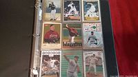 Photo of Roger Clemens baseball cards in a binder sleeve with 9 cards visible showing various poses and card designs.