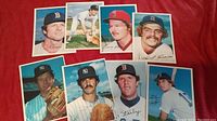 Full view of 8 1981 Topps Giant trading cards laid out on a red background showing portraits and action baseball imagery of Red Sox and Yankees players.